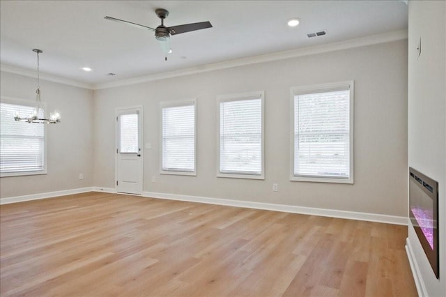 unfurnished living room with a wealth of natural light, light hardwood / wood-style floors, and ornamental molding