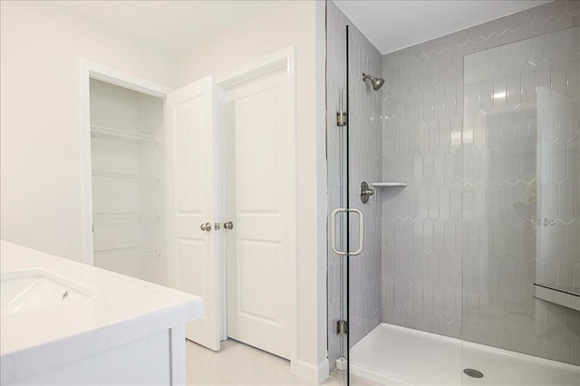 bathroom featuring tile patterned flooring, vanity, and walk in shower