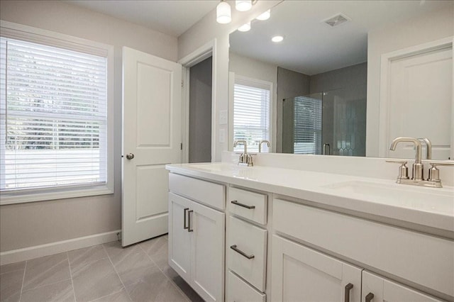 bathroom with vanity, a wealth of natural light, and a shower with shower door