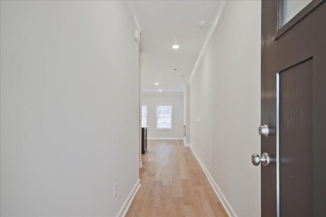 doorway featuring crown molding and light hardwood / wood-style flooring