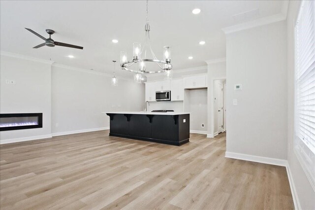 unfurnished living room featuring crown molding, a wealth of natural light, and light hardwood / wood-style flooring