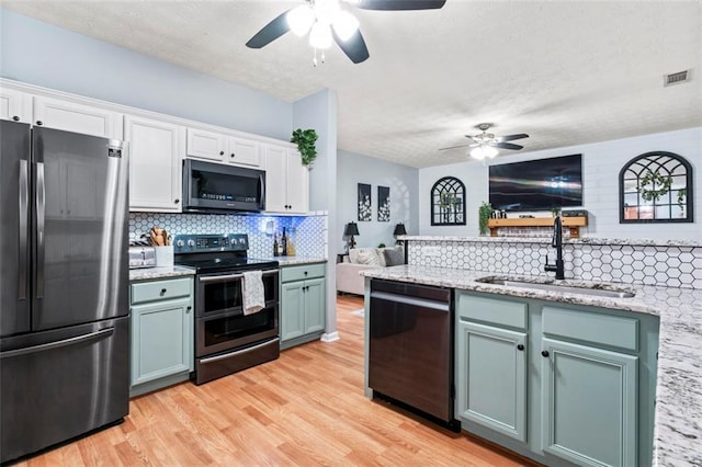 kitchen featuring ceiling fan, white cabinets, stainless steel appliances, and sink