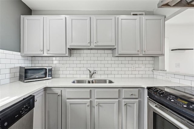 kitchen featuring decorative backsplash, sink, white cabinetry, and stainless steel appliances