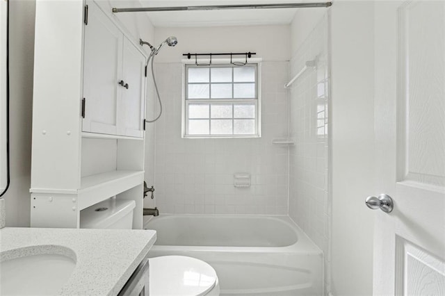 full bathroom featuring vanity, tiled shower / bath combo, and toilet