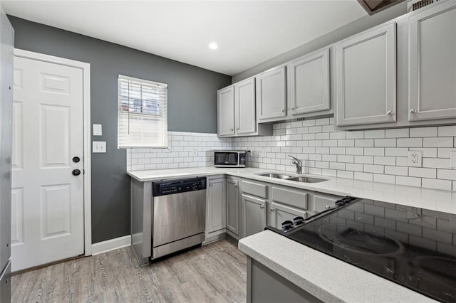 kitchen with gray cabinets, light wood-type flooring, sink, and appliances with stainless steel finishes