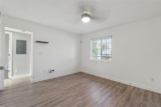 empty room featuring ceiling fan, wood-type flooring, and electric panel