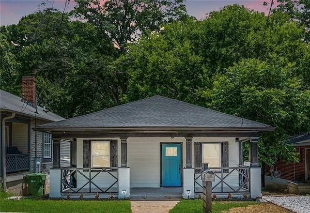 bungalow-style home with covered porch and a shingled roof