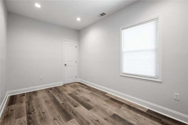 spare room with recessed lighting, visible vents, baseboards, and wood finished floors