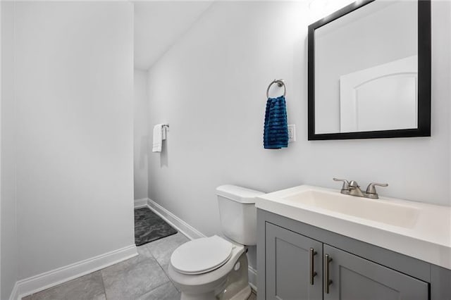 bathroom featuring vanity, toilet, and baseboards