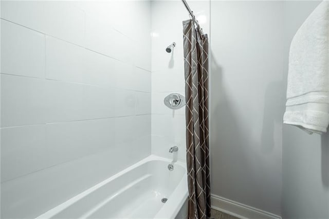 full bathroom with baseboards and shower / bathtub combination with curtain