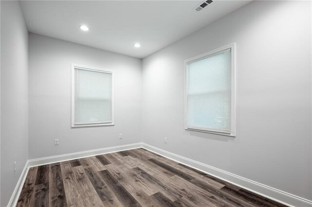 unfurnished room with recessed lighting, baseboards, visible vents, and dark wood-style flooring