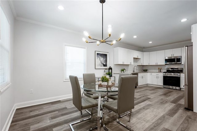 dining space with recessed lighting, wood finished floors, baseboards, and ornamental molding