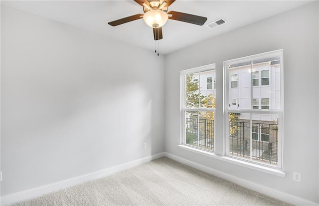 carpeted empty room featuring ceiling fan and a healthy amount of sunlight