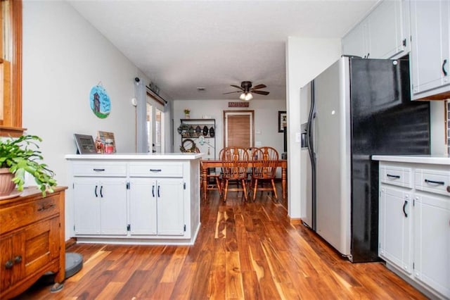 kitchen featuring a peninsula, wood finished floors, refrigerator with ice dispenser, and white cabinets