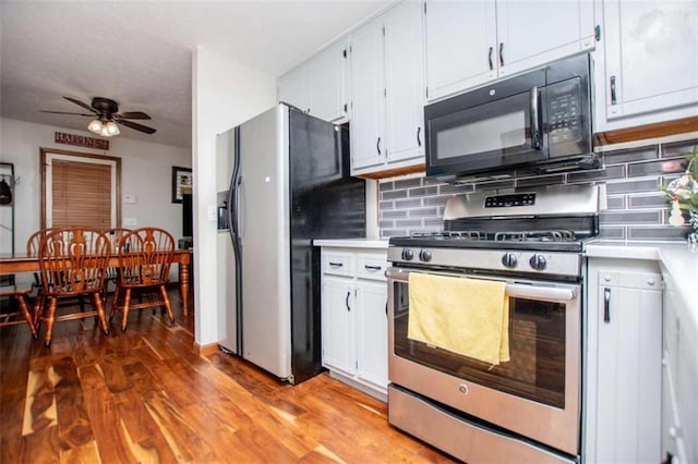 kitchen featuring stainless steel gas stove, fridge with ice dispenser, black microwave, and light countertops