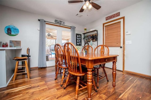 dining room with visible vents, ceiling fan, baseboards, and wood finished floors