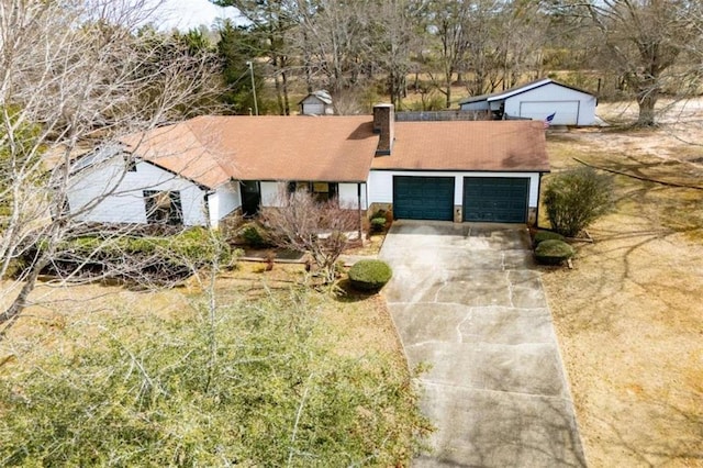 view of front of property with a garage, concrete driveway, and a chimney