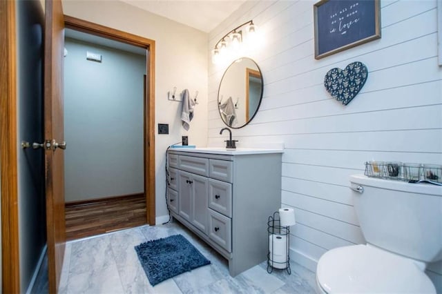 bathroom featuring toilet, vanity, and baseboards