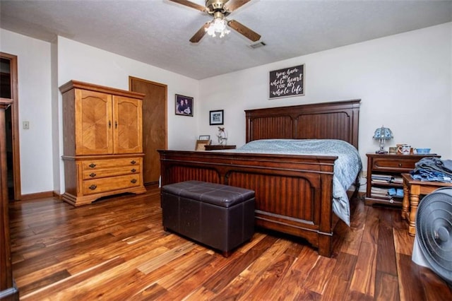 bedroom with baseboards, visible vents, a ceiling fan, wood finished floors, and a textured ceiling