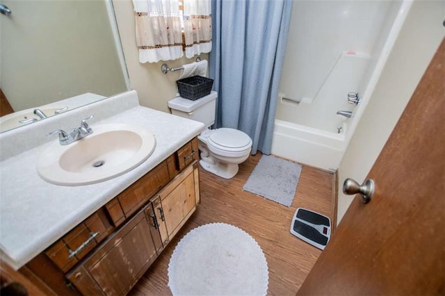 full bath with toilet, shower / bath combo with shower curtain, wood finished floors, and vanity