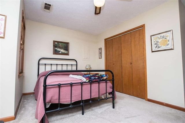 bedroom featuring ceiling fan, visible vents, baseboards, a closet, and carpet