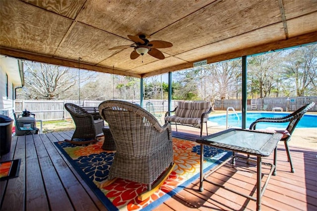 wooden terrace featuring ceiling fan, a fenced backyard, outdoor dining area, and a fenced in pool