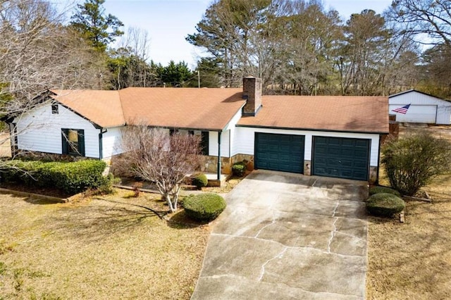 ranch-style home with a garage, concrete driveway, a chimney, and stone siding