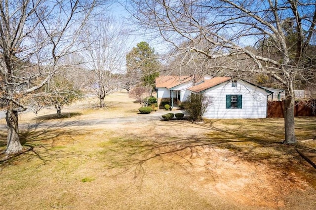 view of yard featuring driveway and fence