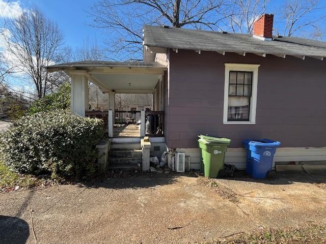 view of side of home featuring covered porch