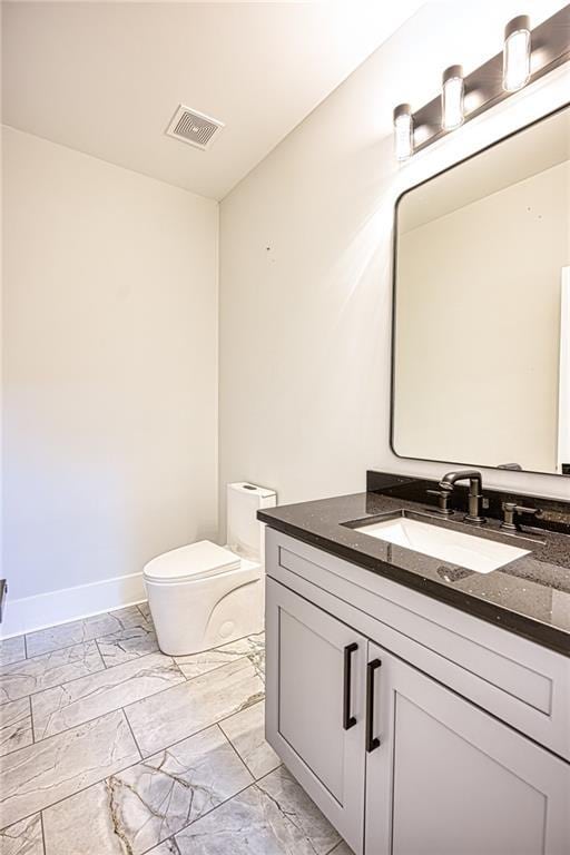 2110 Fairway Cir NE, Brookhaven, GA 30319 - bathroom featuring marble look tiles, toilet, vanity, and baseboards