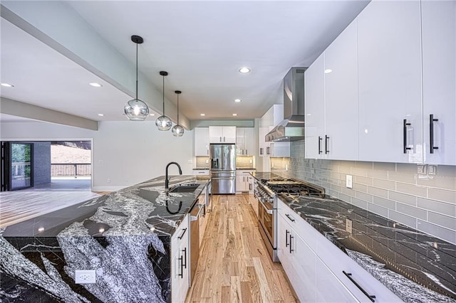 2110 Fairway Cir NE, Brookhaven, GA 30319 - kitchen with appliances with stainless steel finishes, wall chimney exhaust hood, light wood-type flooring, a sink, and dark stone countertops
