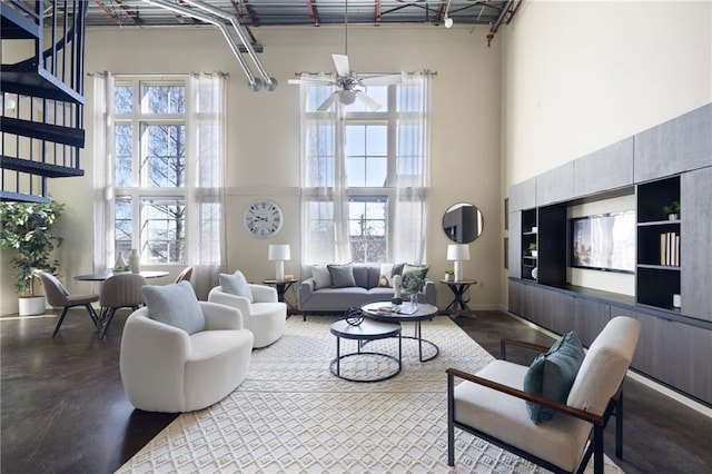 living room with ceiling fan, a high ceiling, and stairs