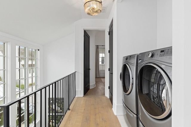 11273 Serenbe Ln, Chattahoochee Hills, GA 30268 - washroom with a notable chandelier, separate washer and dryer, and light hardwood / wood-style flooring