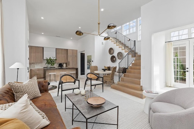 11273 Serenbe Ln, Chattahoochee Hills, GA 30268 - living room with a healthy amount of sunlight, a towering ceiling, and a chandelier