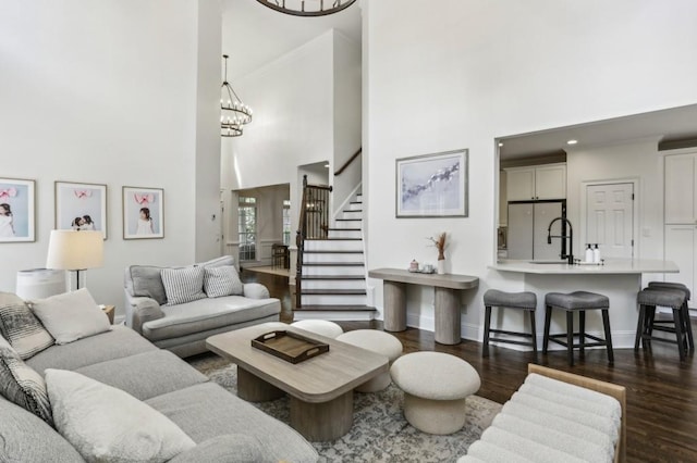 4944 Dovecote Trl, Suwanee, GA 30024 - living area featuring a high ceiling, dark wood-style flooring, stairs, crown molding, and a chandelier