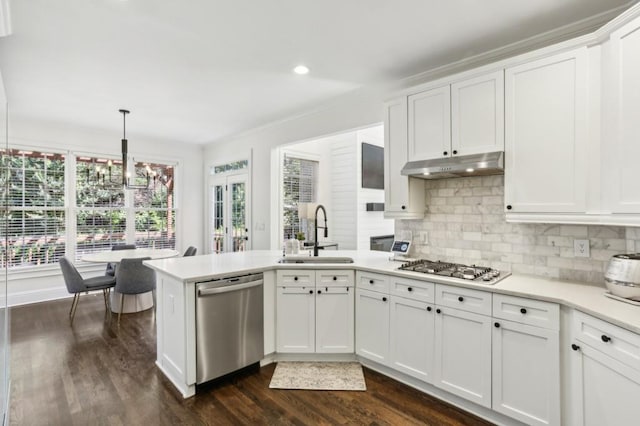 4944 Dovecote Trl, Suwanee, GA 30024 - kitchen with appliances with stainless steel finishes, under cabinet range hood, dark wood finished floors, white cabinetry, and light countertops