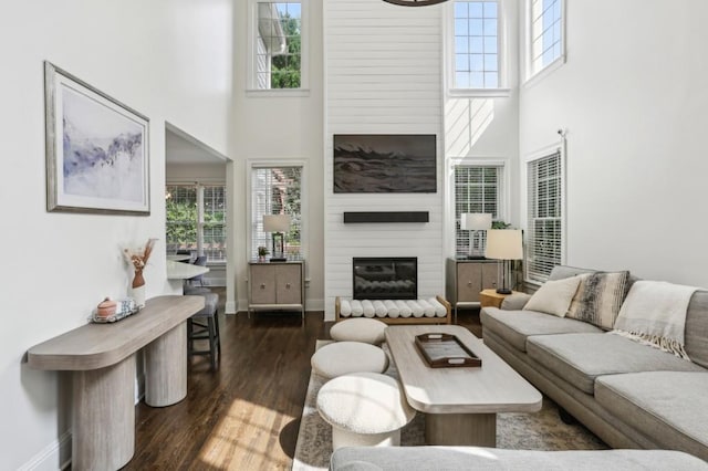 4944 Dovecote Trl, Suwanee, GA 30024 - living room with a towering ceiling, dark wood-type flooring, healthy amount of natural light, and a fireplace