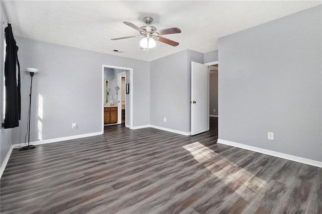 unfurnished bedroom with dark wood finished floors, visible vents, a ceiling fan, connected bathroom, and baseboards