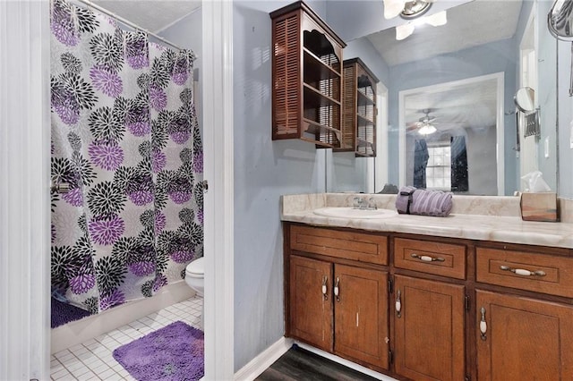 bathroom with baseboards, a shower with shower curtain, toilet, tile patterned flooring, and vanity