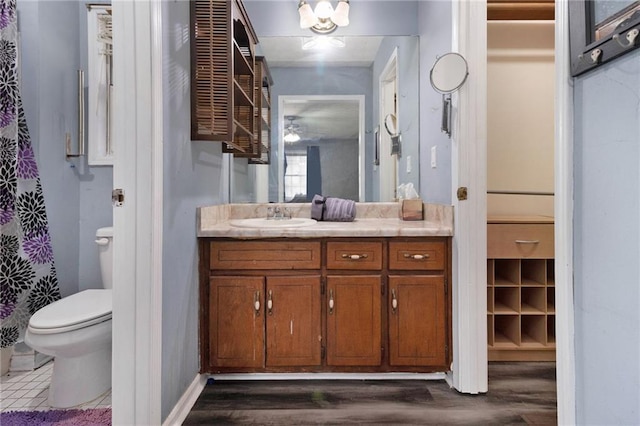 bathroom with toilet, wood finished floors, and vanity