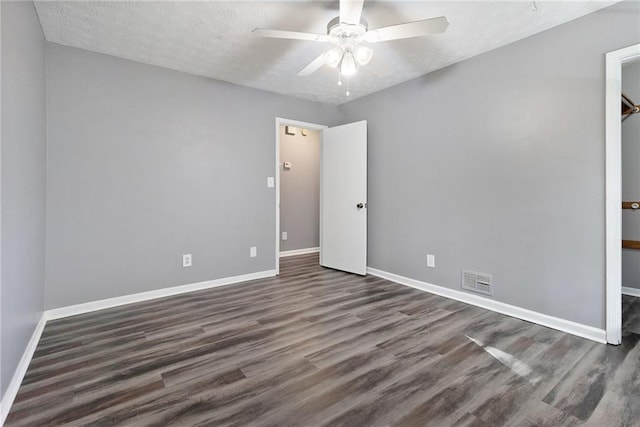 unfurnished bedroom featuring baseboards, a textured ceiling, visible vents, and wood finished floors