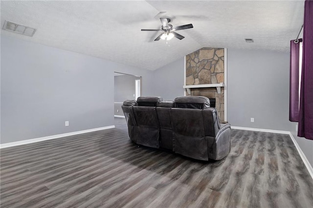 living room with lofted ceiling, visible vents, dark wood finished floors, and a textured ceiling