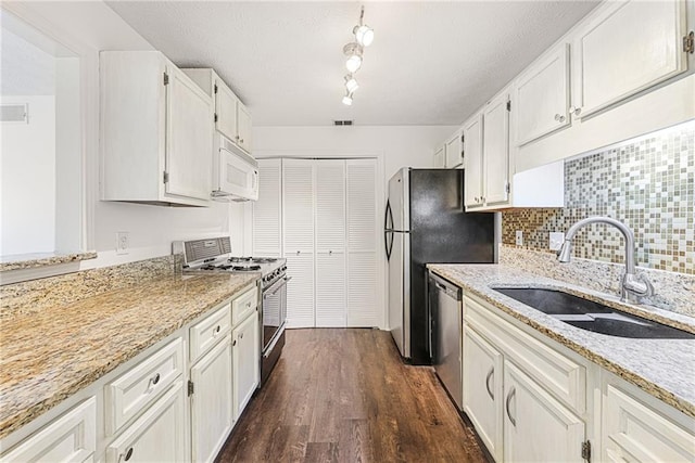 kitchen featuring stainless steel appliances, white cabinetry, sink, and light stone counters