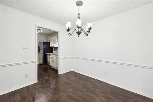 unfurnished dining area featuring an inviting chandelier and dark hardwood / wood-style floors