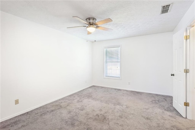 unfurnished room with a textured ceiling, ceiling fan, and light colored carpet