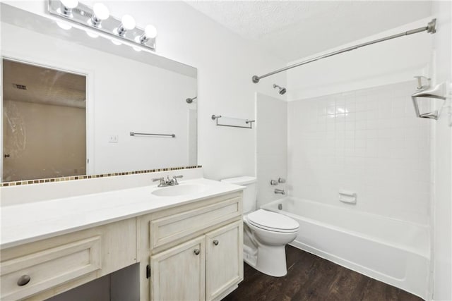 full bathroom featuring toilet, vanity, hardwood / wood-style flooring, a textured ceiling, and shower / bathtub combination