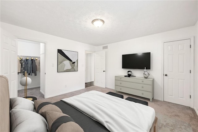 carpeted bedroom featuring a closet and a textured ceiling