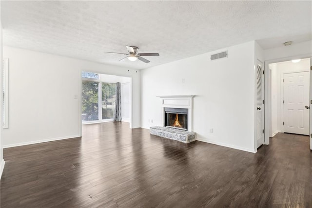 unfurnished living room with a textured ceiling, ceiling fan, and dark hardwood / wood-style flooring