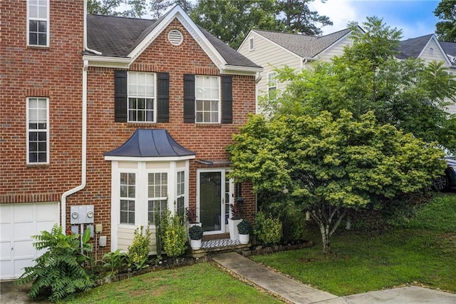 view of property featuring a front yard and a garage