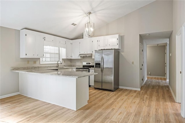 kitchen featuring under cabinet range hood, appliances with stainless steel finishes, a peninsula, light wood finished floors, and lofted ceiling